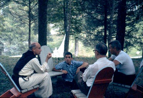 Daniel Berrigan is pictured in a blue plaid shirt in center with Merton seated on the photo's left and Phillip Berrigan on the far right (other person identified as Tony Walsh).  Photo from August 1962 Retreat.  (Copyright Thomas Merton Legacy Trust.)